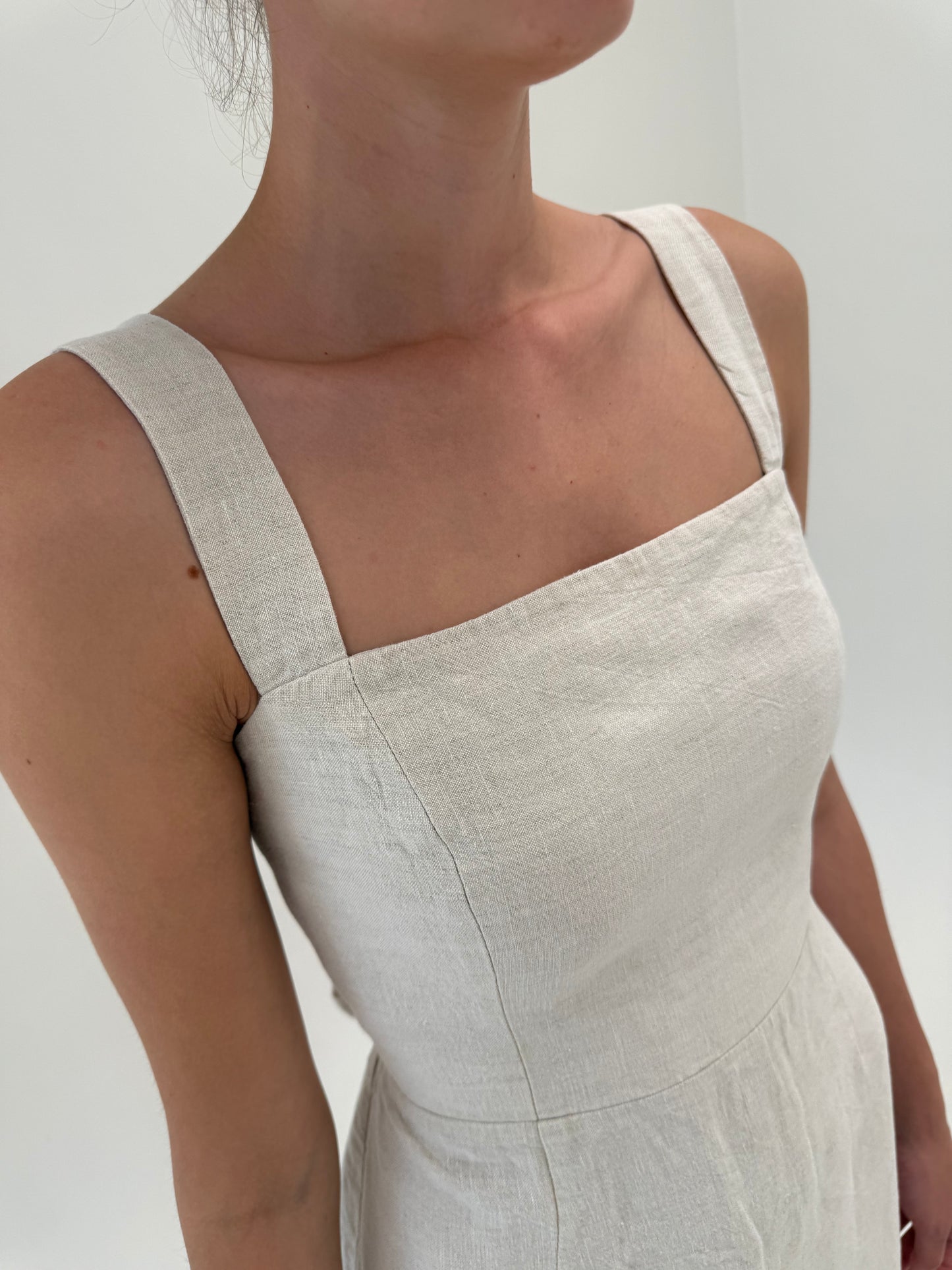 Rochie în croi minimalist cu decupaj la spate și corsaj din pânză de in sand nude