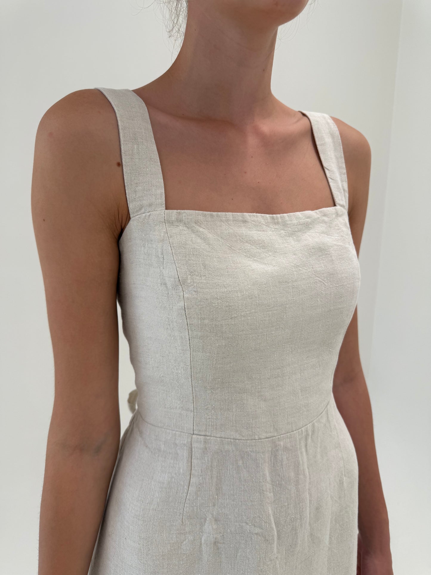 Rochie în croi minimalist cu decupaj la spate și corsaj din pânză de in sand nude